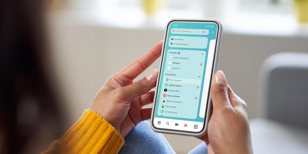 Pharmacienne en train de regarder Maiia Connect sur son smartphone