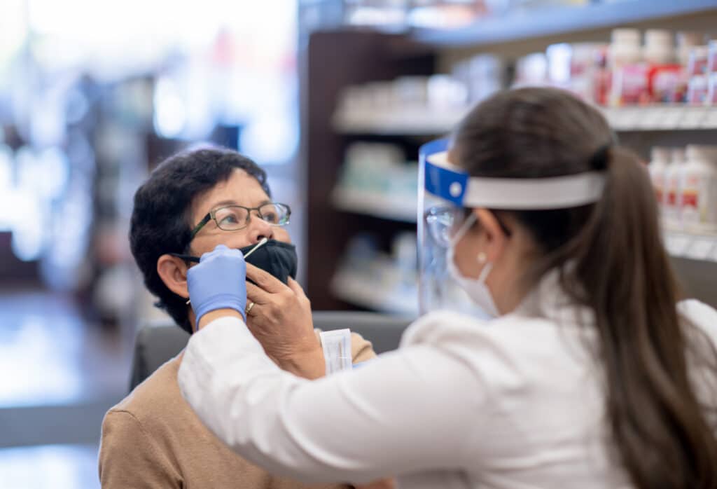 Pharmacienne effectuant une nouvelle mission de test antigénique sur une patiente